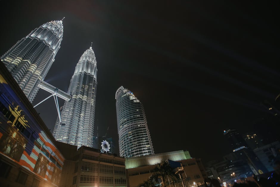 Torres Petronas de Kuala Lumpur de noche — conexión 5G Maxis y CelcomDigi vía DNB en Malasia