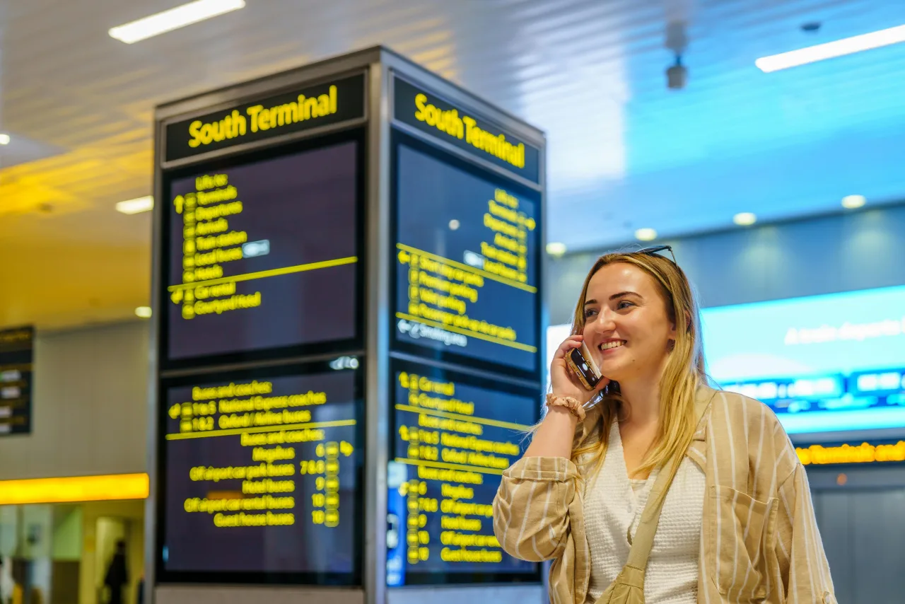 Viajero revisando su celular después de aterrizar en un aeropuerto turco