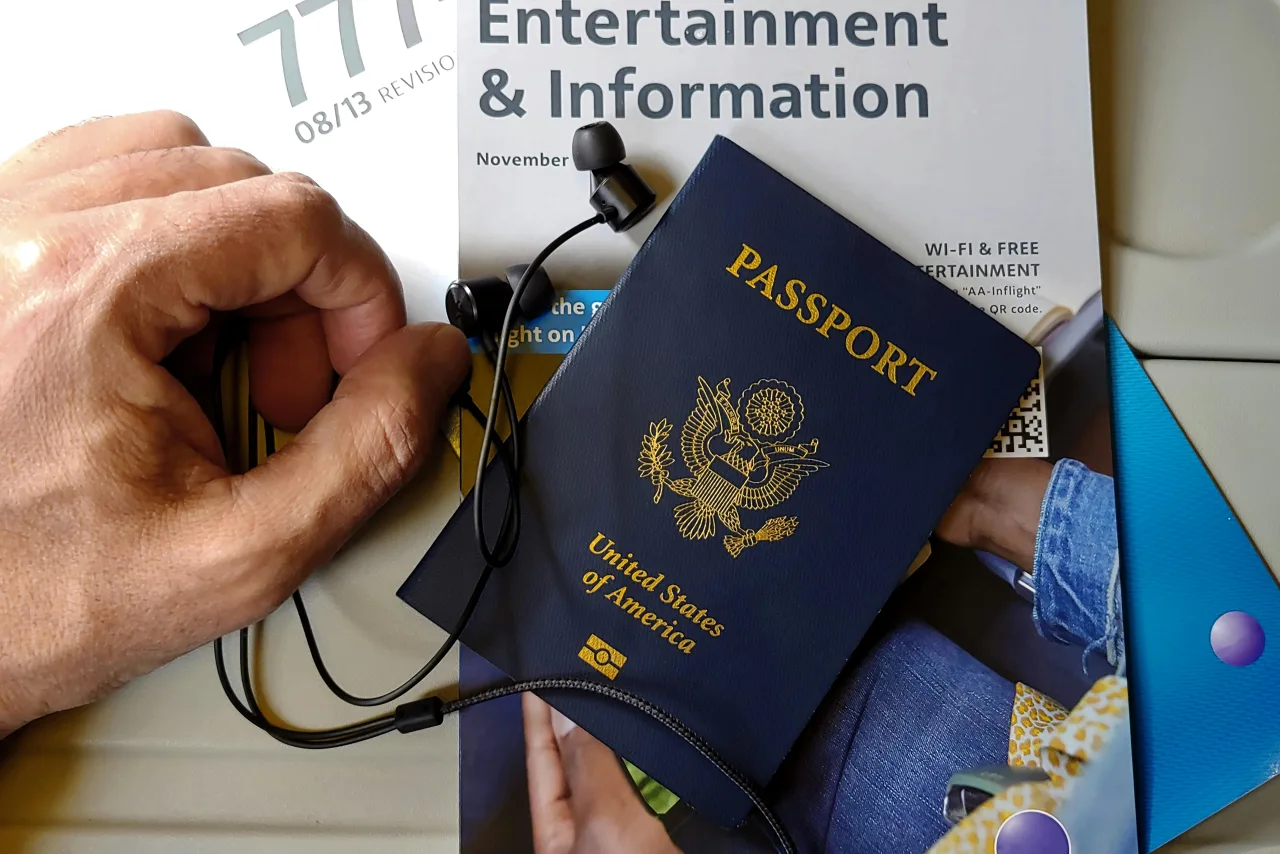Viajero en el aeropuerto revisando su celular antes de un vuelo